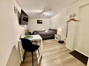 a bedroom with a bed and a desk in a room at Litle cozy apartment in Ålesund in Ålesund
