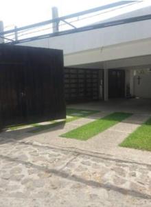 a building with a fence and a courtyard with grass at MI CASA EN TEPOZTLAn in Tepoztlán