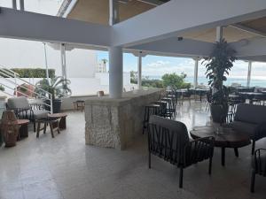 a restaurant with a bar with chairs and tables at Vrachia Beach Hotel & Suites - Adults Only in Paphos