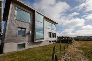 a house with glass windows on the side of it at Vestre Karmøyveg 845 in Karmøy