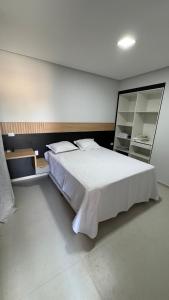 a bedroom with a large white bed and a mirror at Casa Villages Piranhas in Piranhas
