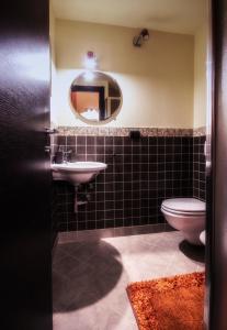 a bathroom with a sink and a toilet and a mirror at La Casetta di Nonna Carmela in Bovino