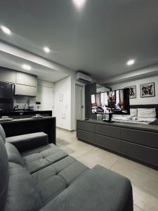 a large living room with a couch and a tv at Studio Duo Jk Evidências 15 in Sao Jose do Rio Preto