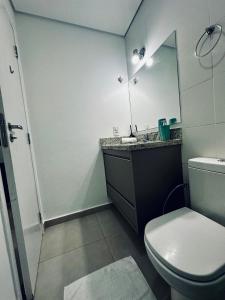 a bathroom with a toilet and a sink and a mirror at Studio Duo Jk Evidências 15 in Sao Jose do Rio Preto