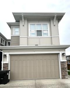 a house with a garage door in front of it at Private Very Spacious 2 bed 1-Bedroom basement Suite SW Calgary in Calgary
