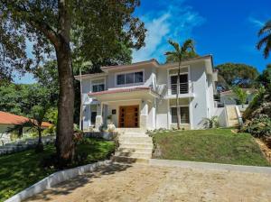 una casa bianca con un albero e scale di Modern 6 Br Villa With Hot Tub a Sosúa