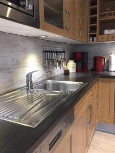a kitchen with a stainless steel sink and wooden cabinets at Zum Rosenhügel in Hellenthal