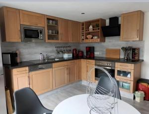 a kitchen with wooden cabinets and a table with chairs at Zum Rosenhügel in Hellenthal
