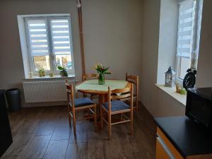a dining room with a table and chairs and two windows at Chaloupka VANYDAN in Vejprty