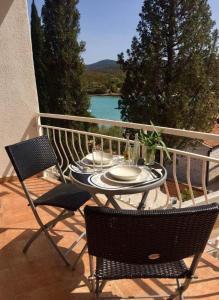 a table and chairs on a balcony with a view of the water at Blue Lagoon Apartment Silver in Lovište