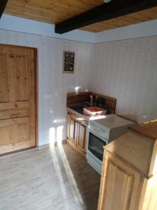 a kitchen with wooden cabinets and a stove top oven at Stara hiža in Radakovo