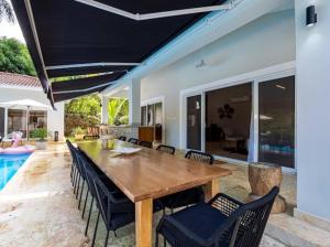 una sala da pranzo con tavolo e sedie in legno di Modern 6 Br Villa With Hot Tub a Sosúa