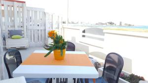 einen Tisch mit einer Blumenvase auf dem Balkon in der Unterkunft Castle on the Sea in Torre Santa Sabina