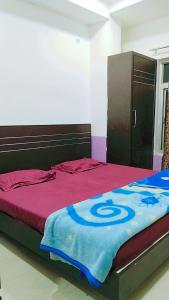 a bed with a blue and red blanket on it at Hotel Love Bite in Hisār