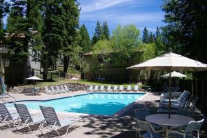 a pool with chairs and a table with an umbrella at Cheyenne's Place home in Kings Beach