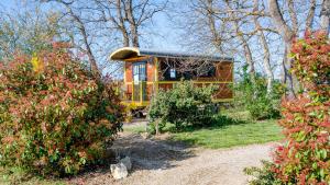 a tiny house in the middle of a garden at Roulotte & Accès SPA Privatif in Pauilhac