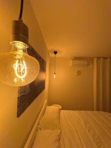 a bedroom with a light hanging over a bed at Chez Nunù in Ercolano