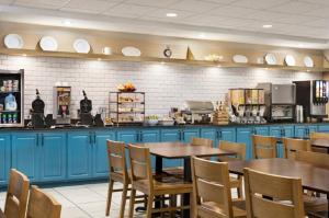 a restaurant with blue cabinets and tables and chairs at Country Inn & Suites by Radisson, Boise West - Meridian in Meridian