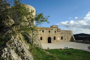 un gran edificio de piedra en la cima de una colina en La Casetta di Nonna Carmela, en Bovino