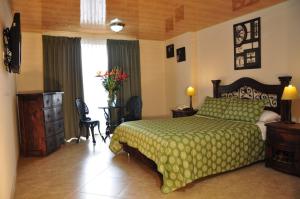 1 dormitorio con 1 cama con colcha verde en Hoteles Bogotá Inn La Soledad, en Bogotá