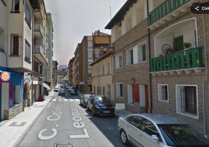 a street with cars parked on the side of the road at Céntrico y equipado apartamento in Sabiñánigo