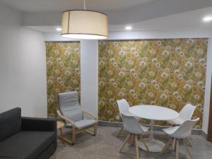 a living room with a couch and a table and chairs at Céntrico y equipado apartamento in Sabiñánigo