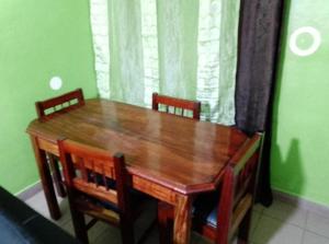 a wooden dining room table with two chairs and a window at Fadilimmo07 in Yaoundé +12 photos