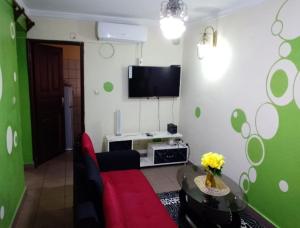 a living room with a red couch and a flat screen tv at Fadilimmo07 in Yaoundé