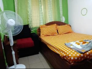 a bedroom with a bed with a fan on it at Fadilimmo07 in Yaoundé