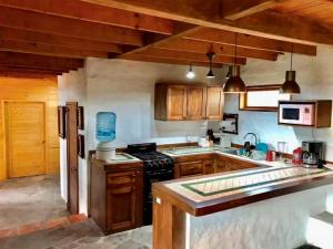 a kitchen with wooden cabinets and a stove at Casa en Tapalpa Cerca del Centro in Tapalpa