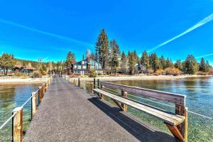 a wooden boardwalk leading to a house on a lake at Park View Paradise condo in Tahoe City