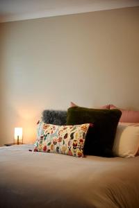 a bedroom with a bed with pillows and a lamp at Ocean Grove retreat in Ocean Grove