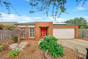 a brick house with a red door and a garage at Ocean Grove retreat in Ocean Grove