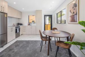 a kitchen with a table and chairs in a room at The Grove Hideaway in Lower Hutt