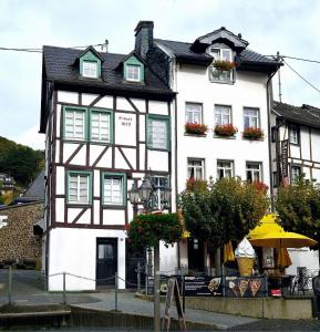 a white and black building with flowers on the windows at NringRooms am Markt in Adenau