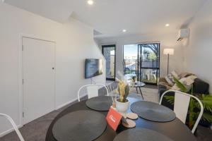 a living room with a table and a couch at Ariki Serenade House 2BR Peaceful Stay in Lower Hutt