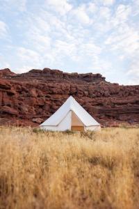 a white tent in front of a rock wall at Glamping Queen Tent At Private Riverside Ranch in Moab +19 photos