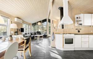 a kitchen and living room with a table and chairs at Holiday Home Orionvej Ã Lbãk Ii in Skram