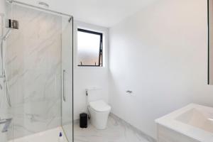 ローワー・ハットにあるPeaceful Escape at Biddle Cresのトイレとシャワー付きの白いバスルーム