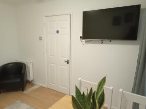 a room with a door and a television on a wall at Bridgewoods in Chatham