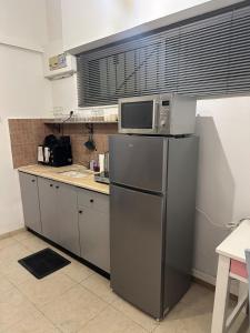 a kitchen with a microwave on top of a refrigerator at Kerem-market Studio 1 in Tel Aviv +9 photos