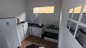 a small kitchen with a stove and a refrigerator at Casa Recanto da Paz in Uberlândia