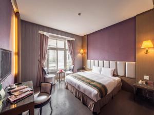 ein Hotelzimmer mit einem Bett und einem Schreibtisch in der Unterkunft Travel Road Motel in Hualien
