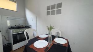 a kitchen with a table with two white plates on it at Casa Recanto da Paz in Uberlândia