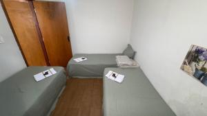 a small room with two beds and a door at Casa Recanto da Paz in Uberlândia +5 photos