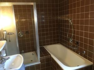 uma casa de banho com um chuveiro, uma banheira e um lavatório. em Appartement Zahn em Bad Waldsee