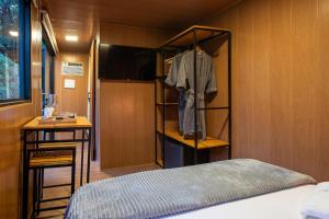 a bedroom with a bed and a shelf with a shirt at Vibe Container CAPARAÓ AMARELO in Pedra Menina