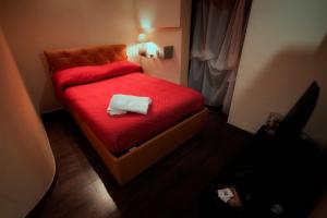 a small bedroom with a red bed with a towel on it at La Casetta di Nonna Carmela in Bovino