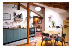 a kitchen with blue cabinets and a table and chairs at Le Petit Balcon Bleu in Rabastens