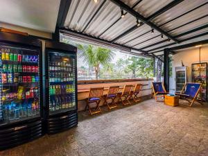 a bar with chairs and a lot of drinks at Laika Hostel in Camburi